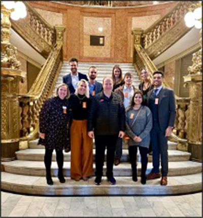 group of people standing on stairs inside state capitol