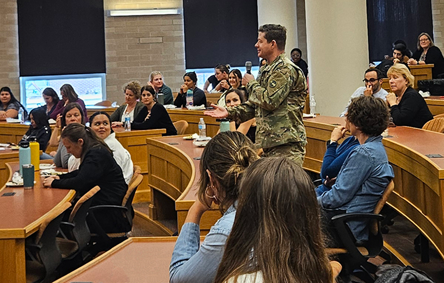 audience member standing with microphone addressing speakers