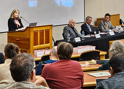 speaker at podium and panelists facing audience